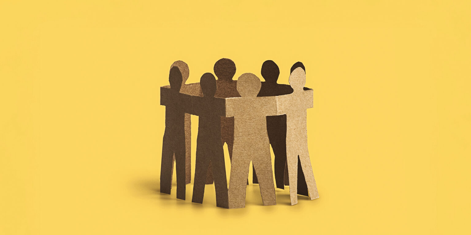 paper cut outs of people huddled in a circle
